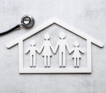 Ilustração de uma família dentro de uma casa com estetoscópio ao lado, simbolizando a relação entre moradia, saúde e qualidade de vida.