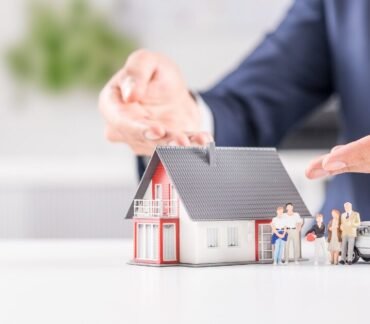 Médico protegendo simbolicamente uma casa e uma família, representando a relação entre moradia, bem-estar e longevidade.