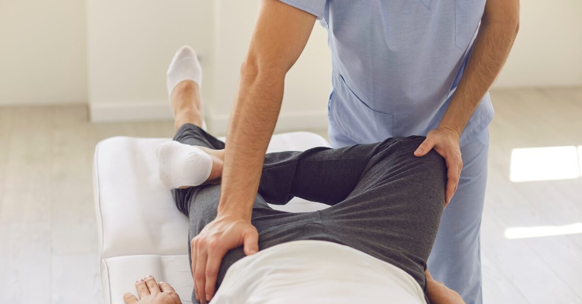 Profissional de saúde realizando alongamento da perna e do quadril de um homem deitado em maca.